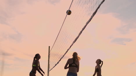 Beachvolleyball-Match-Mädchen-Schlagen-Den-Ball-In-Zeitlupe-Bei-Sonnenuntergang-Auf-Dem-Sand